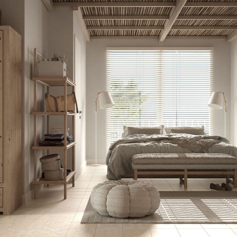 Cosy wooden peaceful bedroom in beige tones, double bed with pillows and blankets, ceramic tiles floor, carpet, poufs, mirror and window with venetian blinds, modern interior design